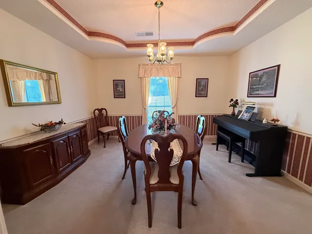 a view of a dining room with furniture and chandelier