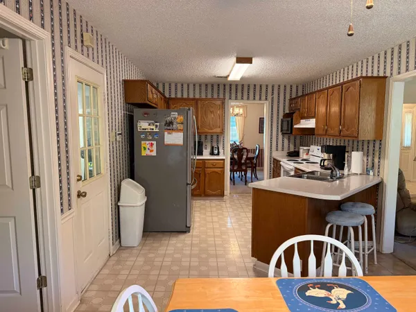 a kitchen with stainless steel appliances granite countertop a stove refrigerator and cabinets