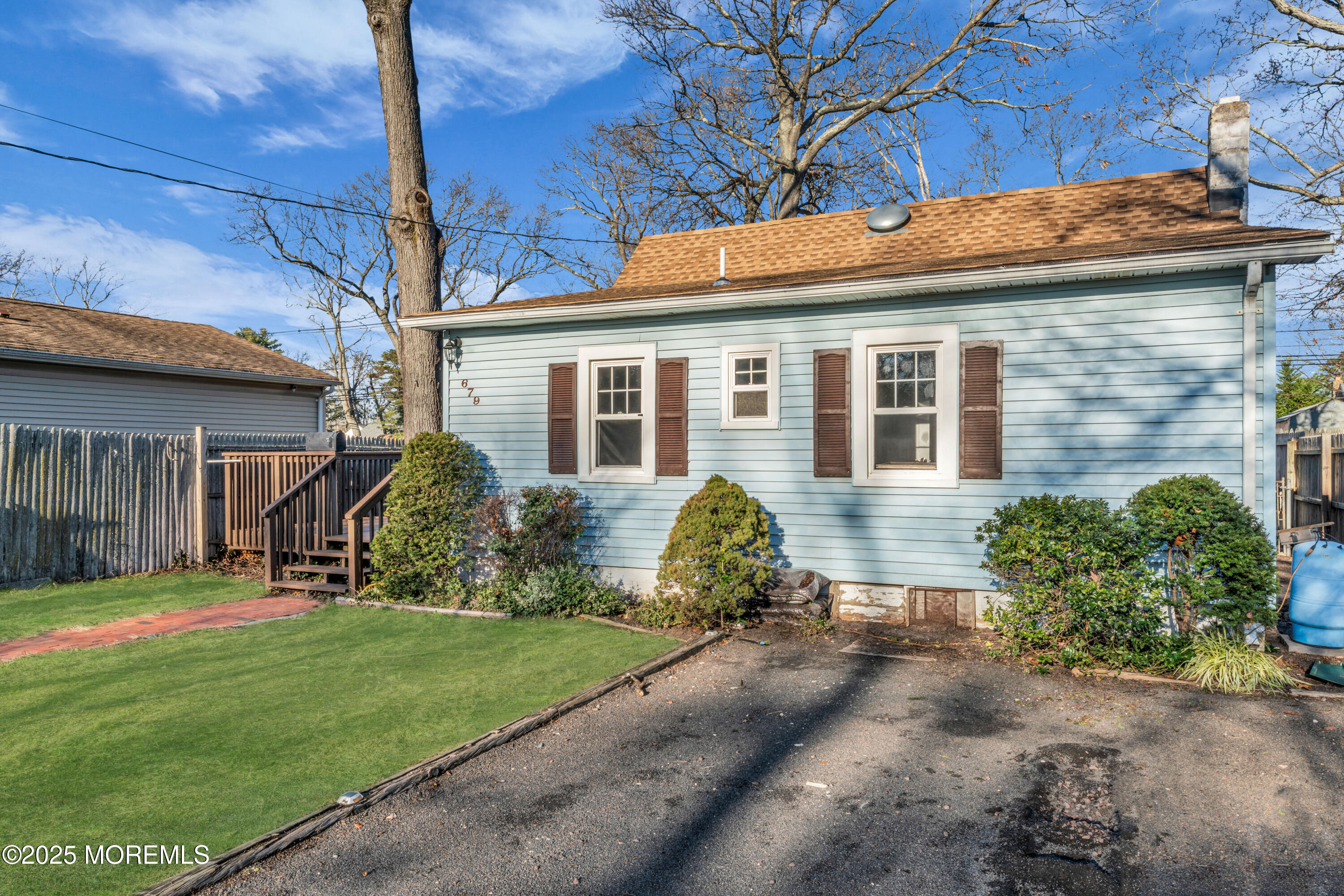 a front view of a house with a yard and potted plants