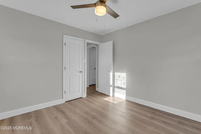a view of an empty room and window and wooden floor