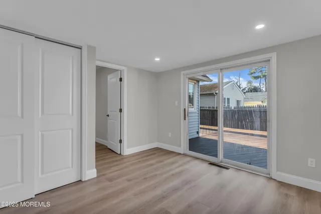 an empty room with wooden floor and sliding door