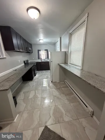 a kitchen with a sink a stove top oven and cabinets