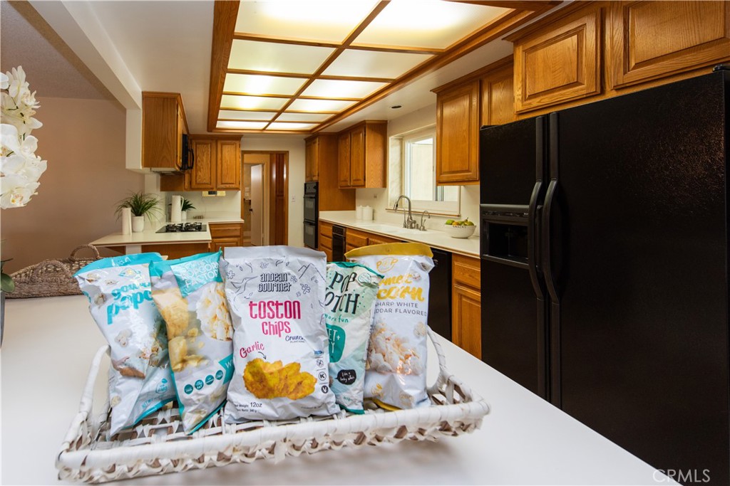 1112 Steele Drive Brea, CA 92821 - Photo 12 of 34 a kitchen with stainless steel appliances kitchen island granite countertop a table chairs in it and wooden floors