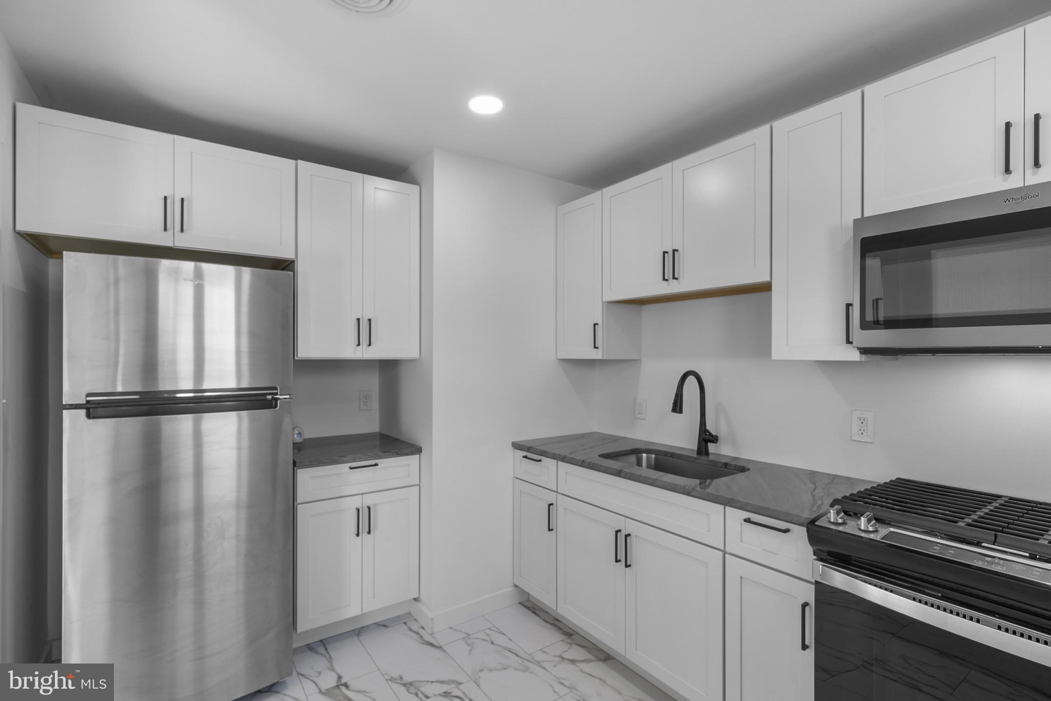 809 South Scott Street Middletown, DE 19709 - Photo 8 of 25 a kitchen with white cabinets sink and white appliances