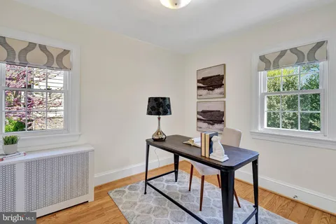 a view of a workspace with furniture and a window