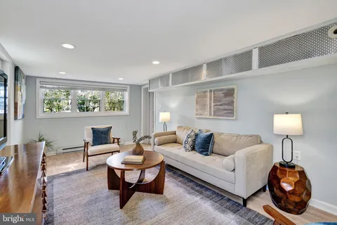 a living room with furniture a lamp a rug and a window