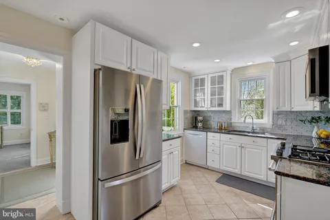 a kitchen with stainless steel appliances granite countertop a refrigerator sink and stove