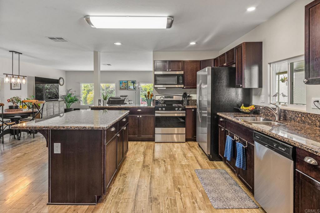 a kitchen with stainless steel appliances granite countertop a stove a sink dishwasher a refrigerator and a oven
