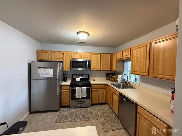 a kitchen with stainless steel appliances a refrigerator stove sink and microwave