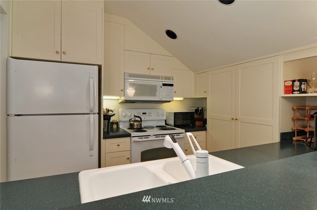 21 Cherry Loop Northwest Shoreline, WA 98177 - Photo 20 of 25 a kitchen with stainless steel appliances a refrigerator sink and white cabinets