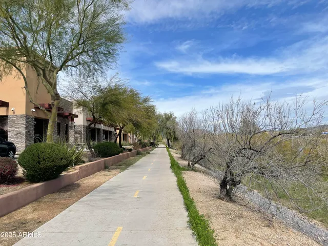 a view of a pathway with a wrought fence