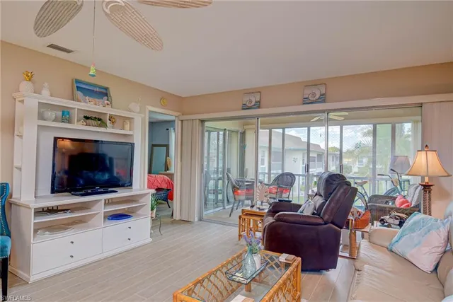 a living room with furniture a flat screen tv and a floor to ceiling window