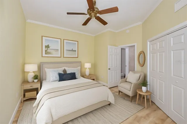 a bedroom with a bed a chair and potted plant