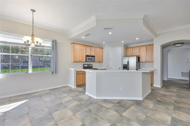 a view of kitchen with stainless steel appliances granite countertop a stove top oven a sink a refrigerator and white cabinets
