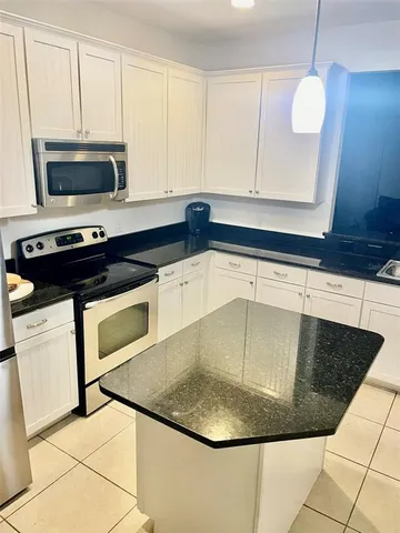 a kitchen with a sink a microwave and cabinets
