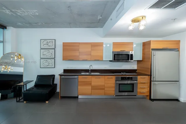 a kitchen with stainless steel appliances granite countertop a refrigerator and a stove top oven