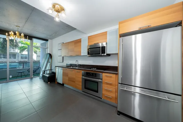 a kitchen with stainless steel appliances a refrigerator sink and microwave