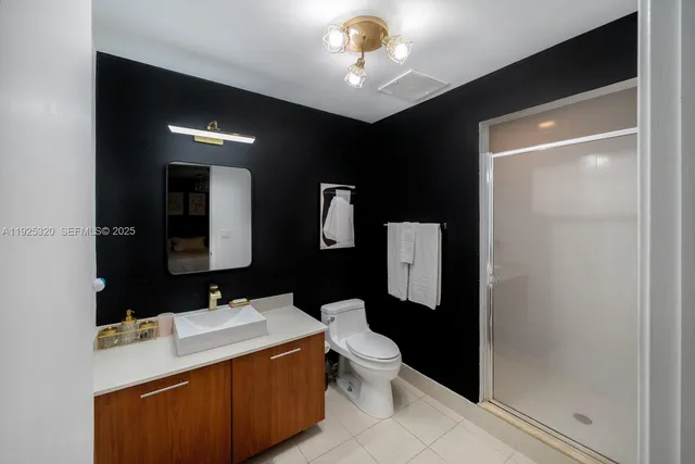 a bathroom with a sink vanity mirror and toilet