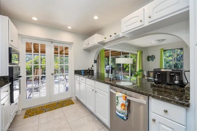 a large kitchen with stainless steel appliances granite countertop a sink and cabinets