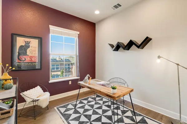 a spacious bedroom with a bed and wooden floor