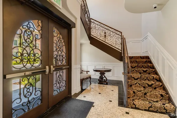 a view of a hallway with bathroom and wooden floor