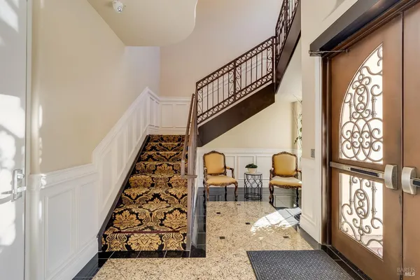 a room with lots of white furniture and a large window