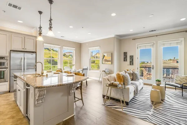 a dining room with stainless steel appliances kitchen island granite countertop a dining table chairs and view kitchen
