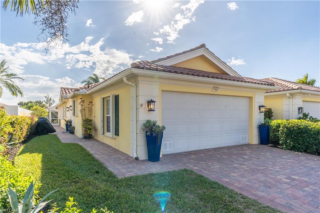 7568 Novara Court Naples, FL 34114 - Photo 1 of 34 a view of a house with a yard and garage
