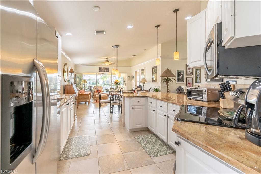 7568 Novara Court Naples, FL 34114 - Photo 14 of 34 a very nice looking dining room with a large kitchen island