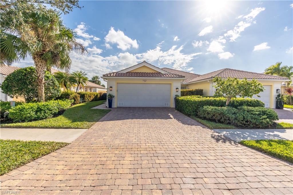 7568 Novara Court Naples, FL 34114 - Photo 2 of 34 a view of a white house with a yard and potted plants