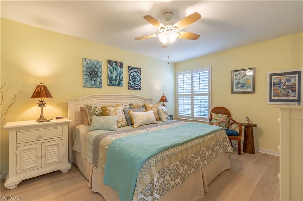7568 Novara Court Naples, FL 34114 - Photo 21 of 34 a bedroom with a bed and a chandelier