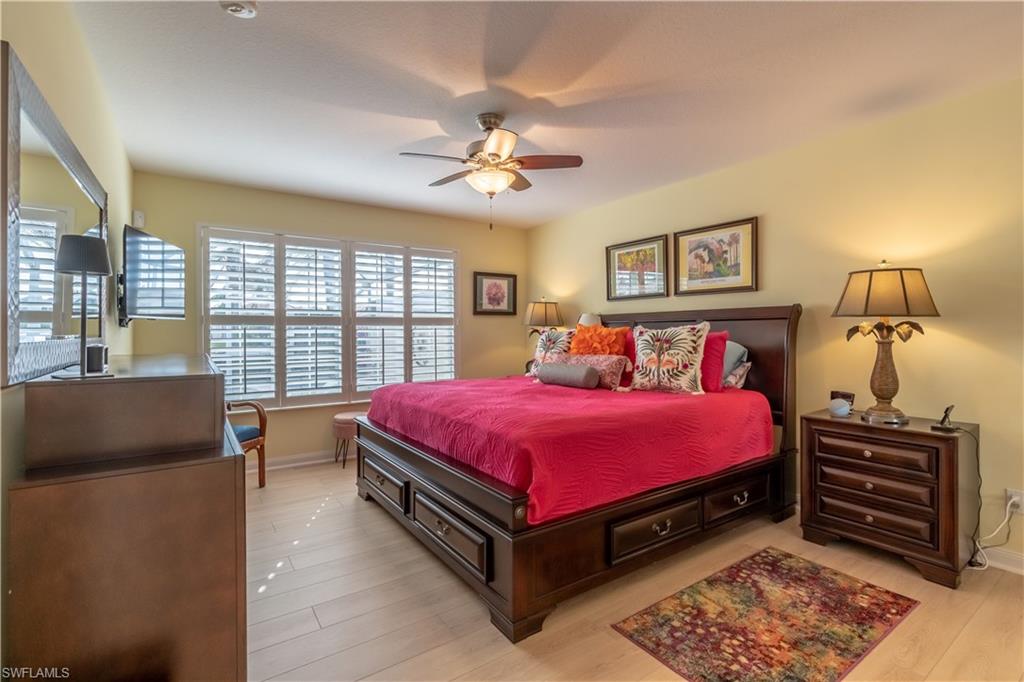 7568 Novara Court Naples, FL 34114 - Photo 23 of 34 a spacious bedroom with a bed and wooden floor