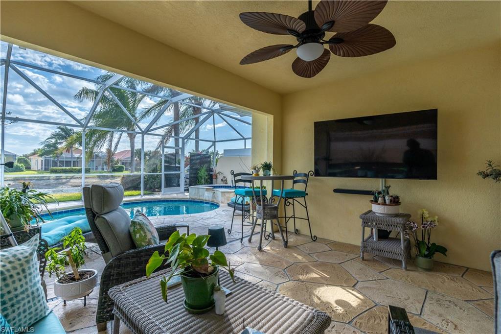 7568 Novara Court Naples, FL 34114 - Photo 27 of 34 a living room with patio furniture and a flat screen tv