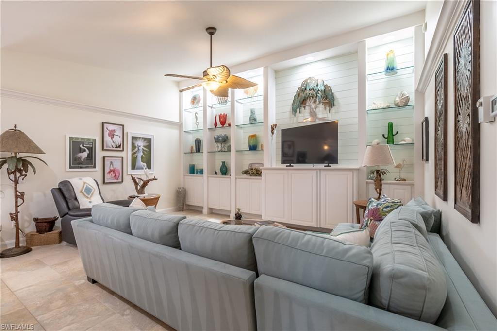 7568 Novara Court Naples, FL 34114 - Photo 7 of 34 a living room with furniture a flat screen tv and a chandelier