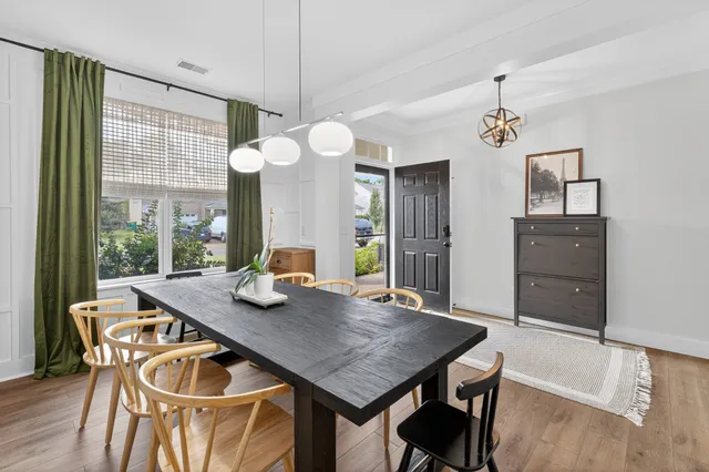 a dining room with furniture a chandelier and wooden floor