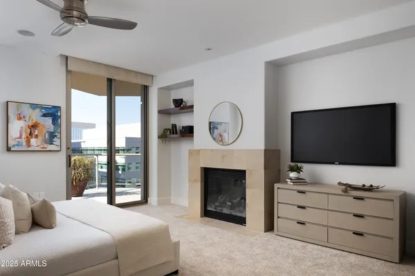 a bedroom with furniture a fireplace and a flat screen tv
