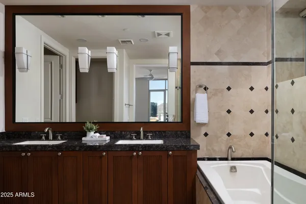 a bathroom with a bathtub and a double vanity sink