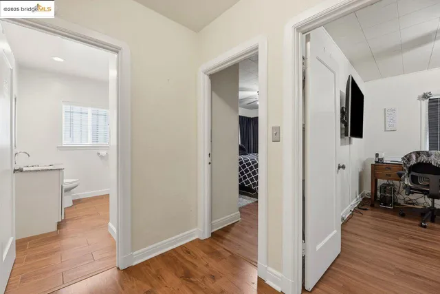 a view of a hallway with bathroom and wooden floor