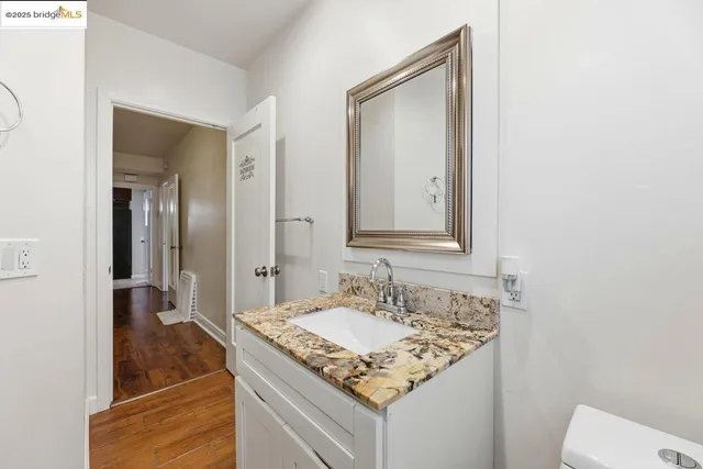 a bathroom with a granite countertop sink and a mirror