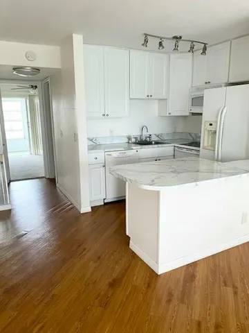 a kitchen with stainless steel appliances granite countertop a white stove top oven and white cabinets