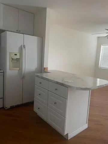 a kitchen with granite countertop cabinets and refrigerator