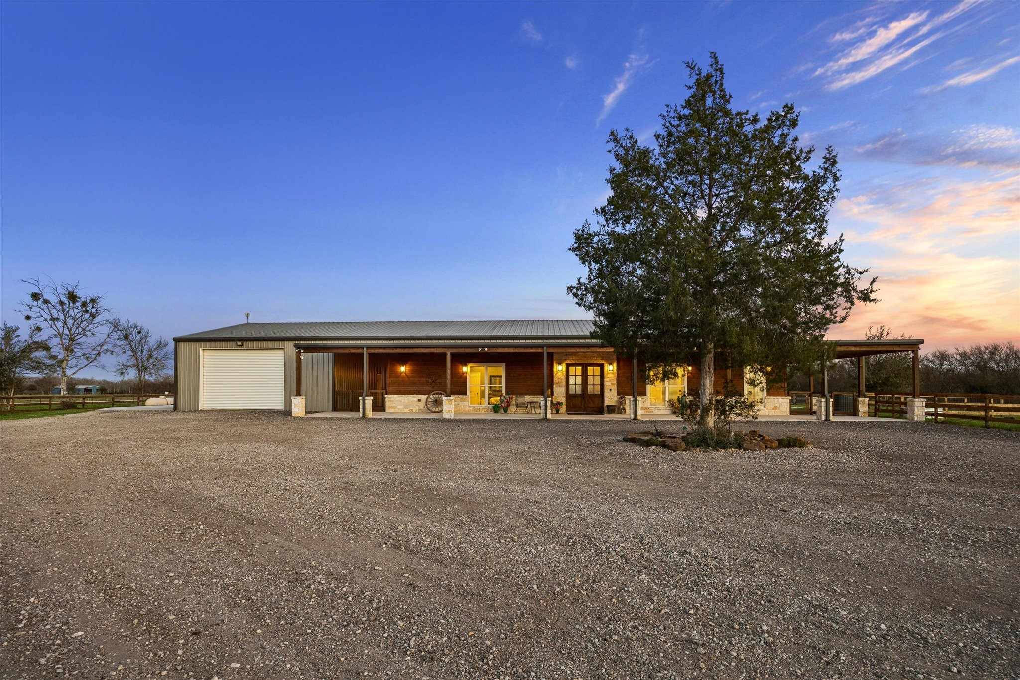 2224 Maler Road Sealy, TX 77474 - Photo 2 of 50 Single-story barn-dominium home with a metal roof and a large garage. Features a spacious gravel driveway and is surrounded by open land, offering a peaceful, country setting.