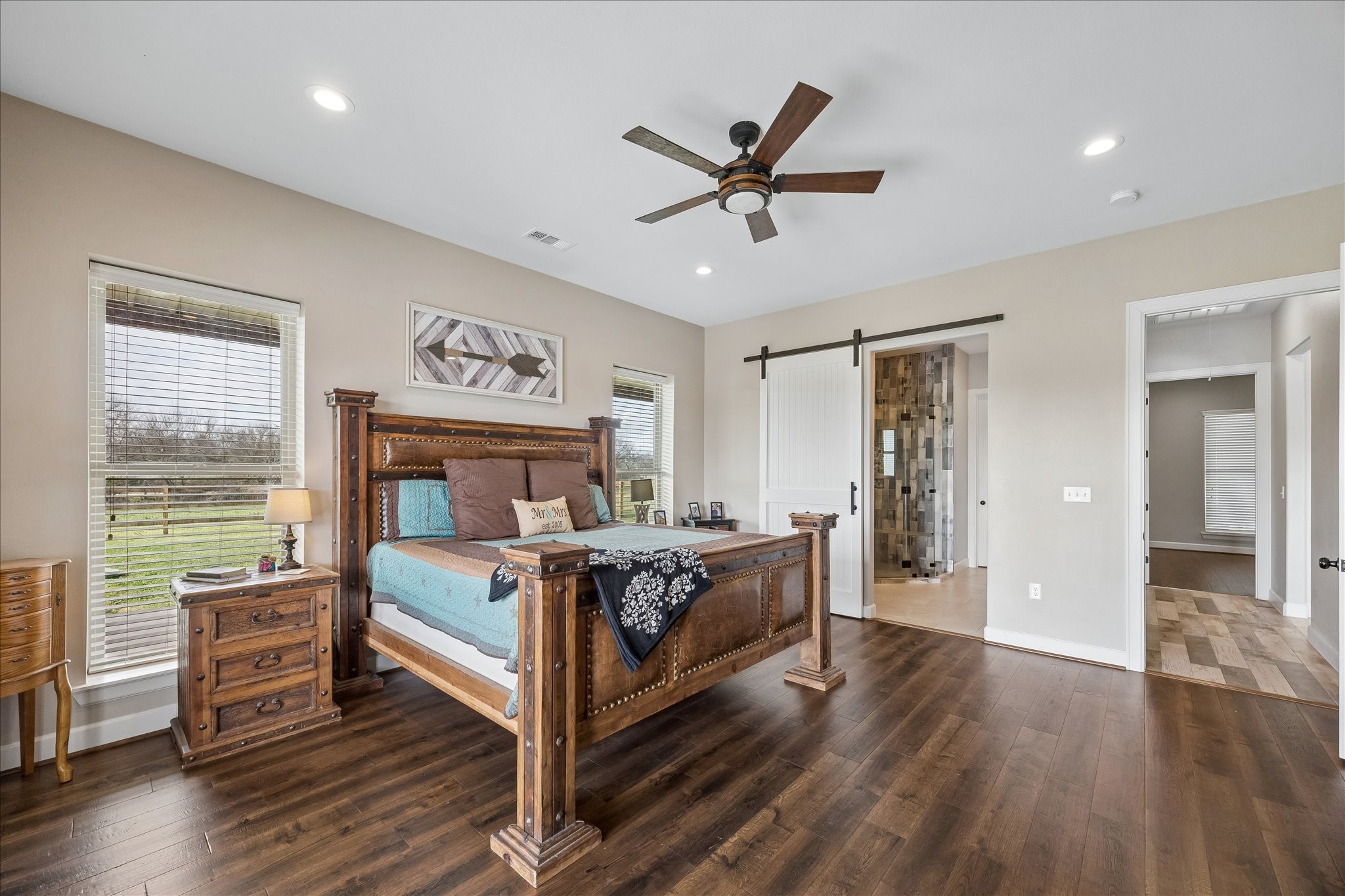 2224 Maler Road Sealy, TX 77474 - Photo 21 of 50 Primary bedroom features hardwood floors, ceiling fan and sliding barn door adding charm.
