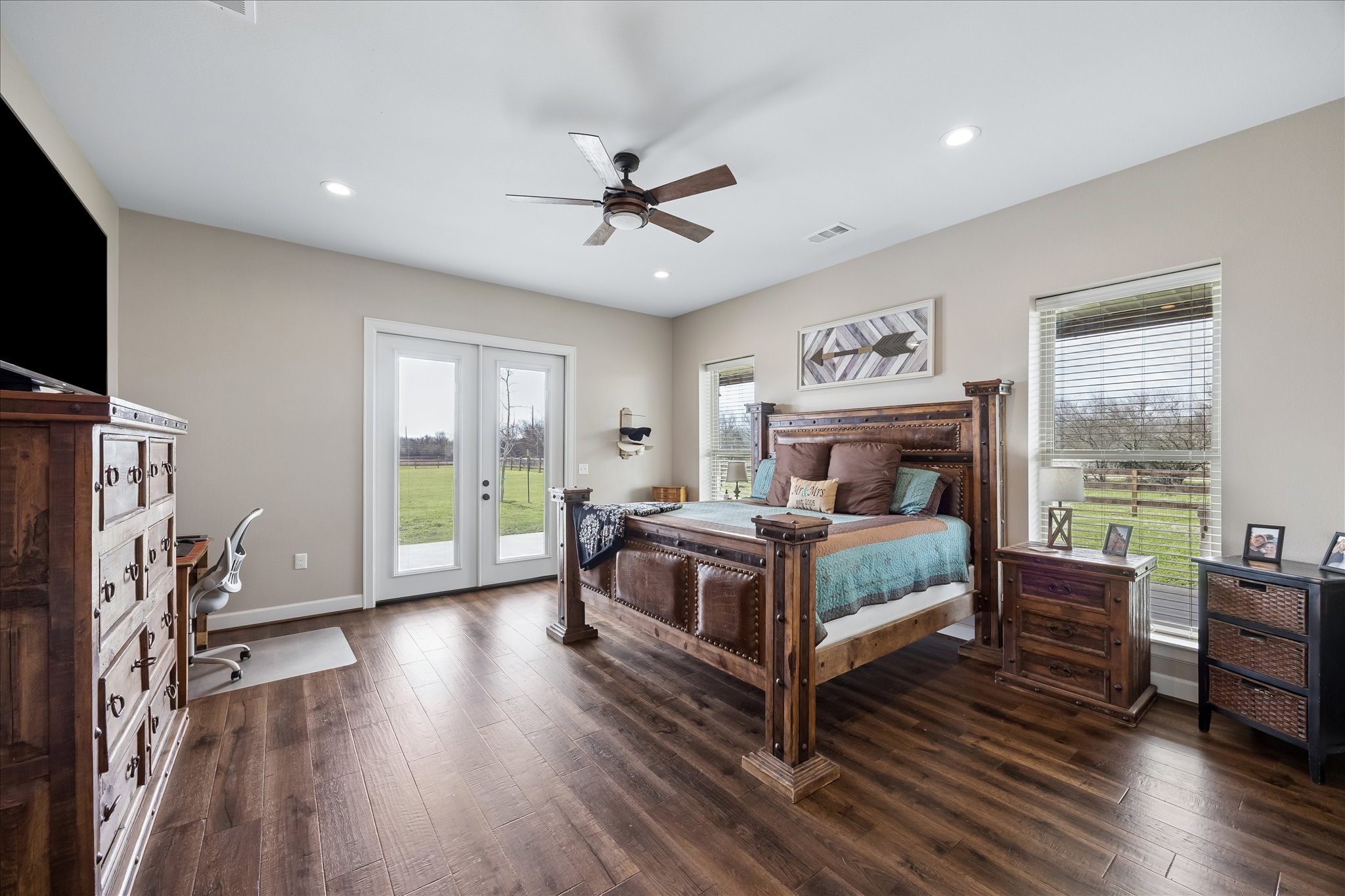 2224 Maler Road Sealy, TX 77474 - Photo 7 of 50 This spacious bedroom has hardwood floors and ample natural light from large windows and French doors that open to the outdoors.