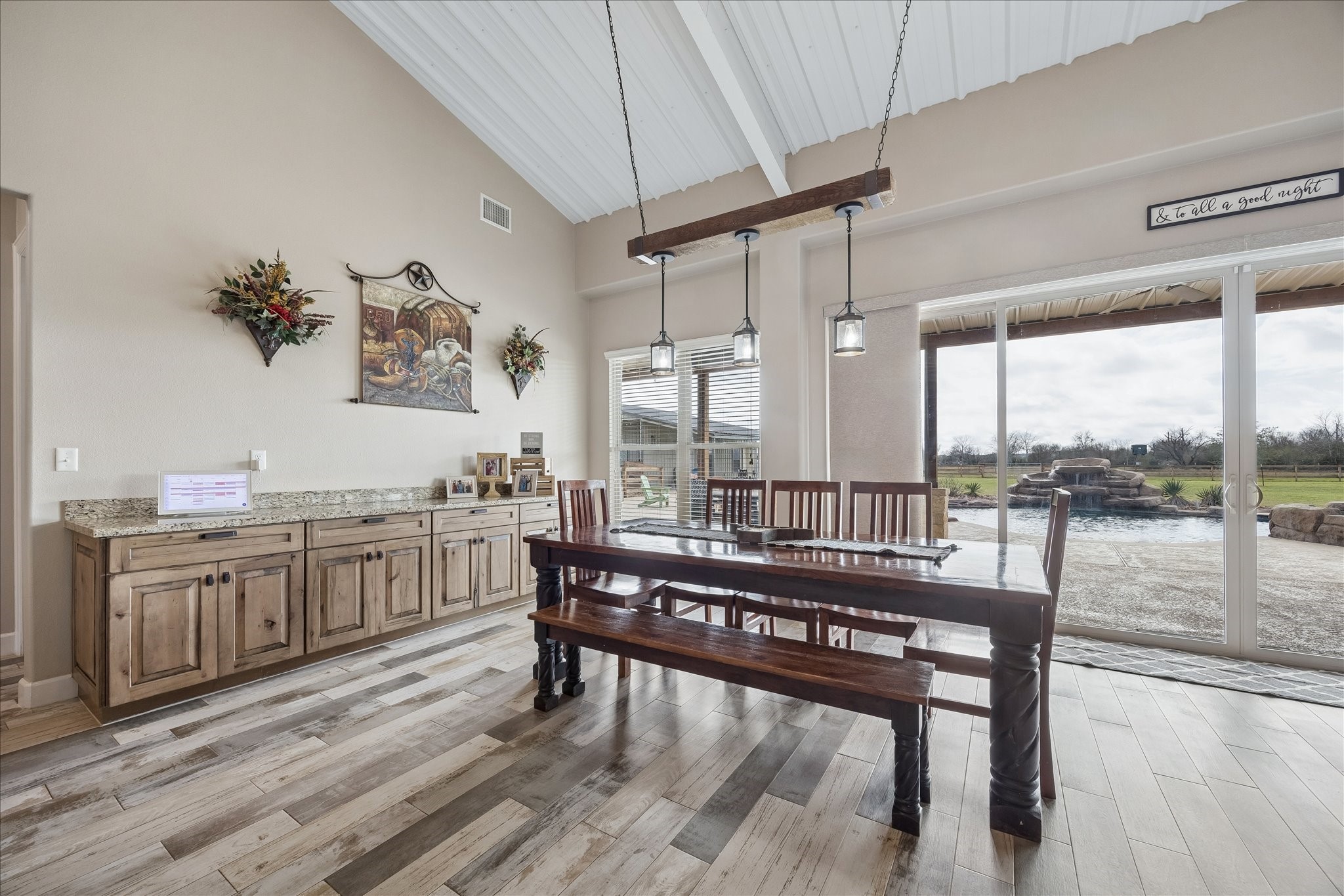 2224 Maler Road Sealy, TX 77474 - Photo 9 of 50 Spacious and bright dining area with high ceilings. Large sliding glass doors open to a patio with a view of a landscaped backyard and pool.