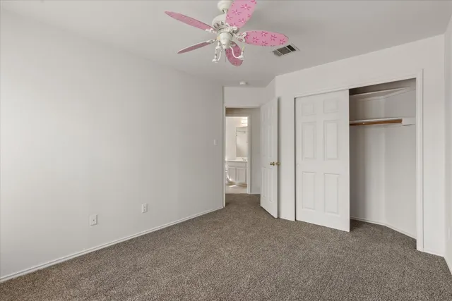 a view of an empty room with a ceiling fan