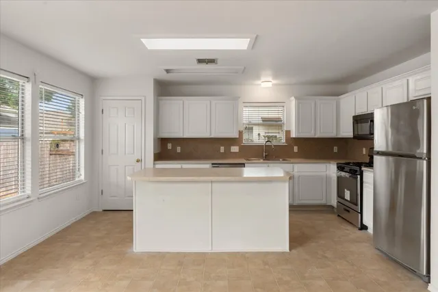 a kitchen with a refrigerator a stove top oven a sink and dishwasher
