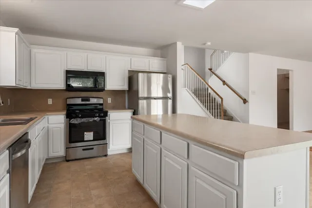 a kitchen with cabinets stainless steel appliances and a counter space