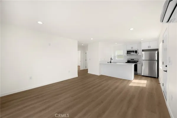 a view of a kitchen with wooden floor and a sink