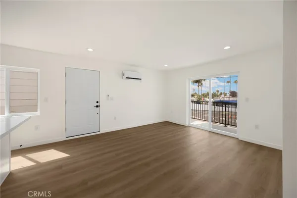 an empty room with wooden floor and white walls